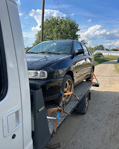 Sötét hatchback szállítása NV trélerrel